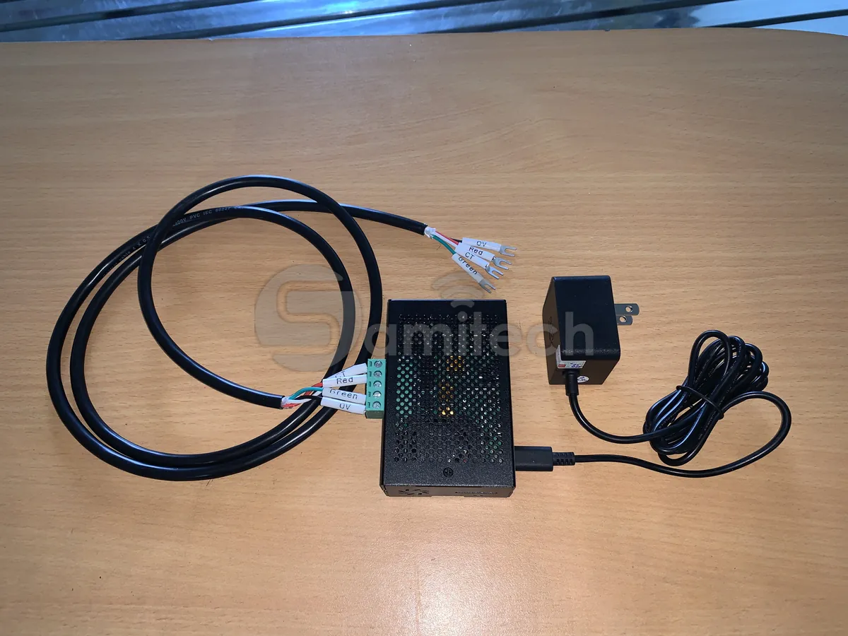 Hộp thiết bị biên đặt trên bàn cùng bó dây tín hiệu đã bấm đầu cos dán nhãn 0V, Red, Green và một bộ nguồn rời.